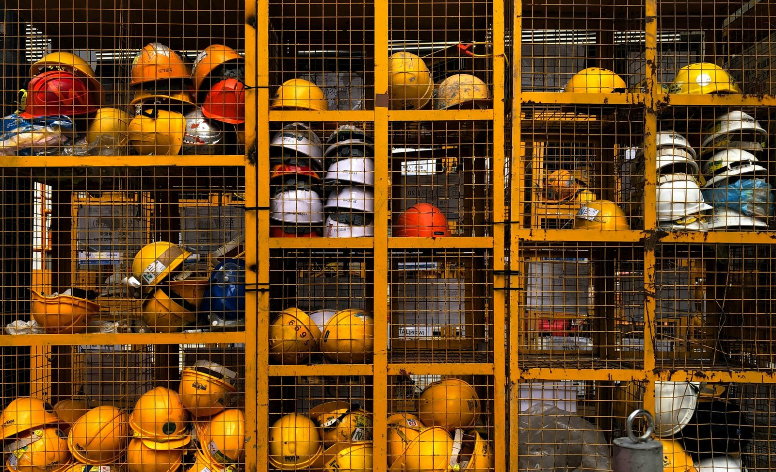 a rack filled with lots of yellow hard hats